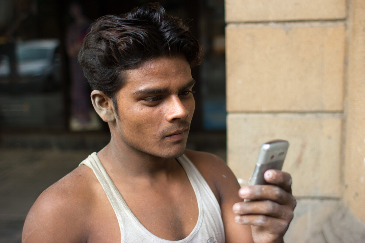 Dignified frontline blue-collar worker in India using smartphone on site with Salary++ earned wage access